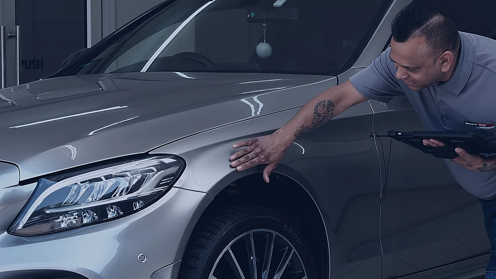 Renew-it service advisor reviewing a digital quotation with a customer beside their vehicle